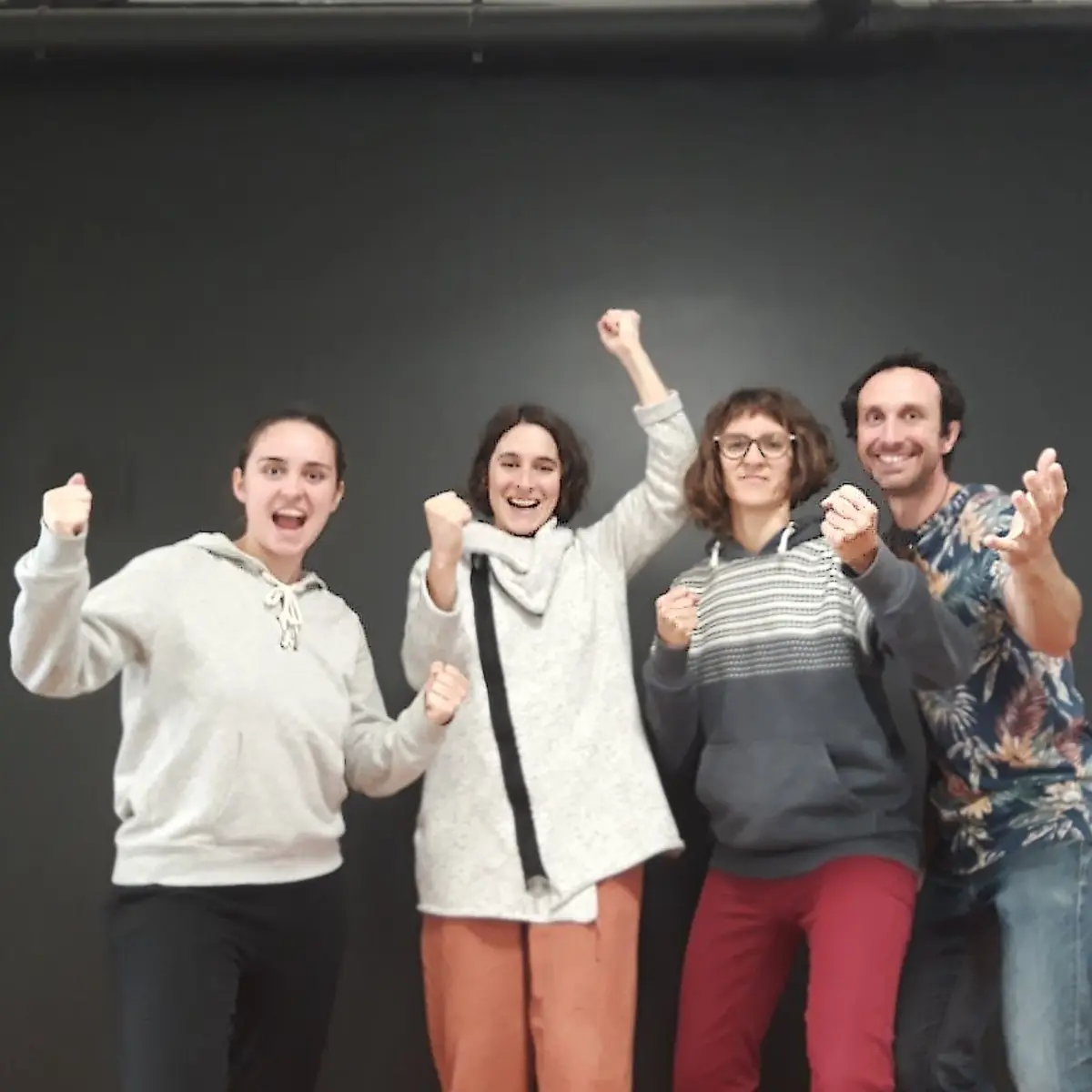 Un groupe, poings levés, à la fin d'un atelier