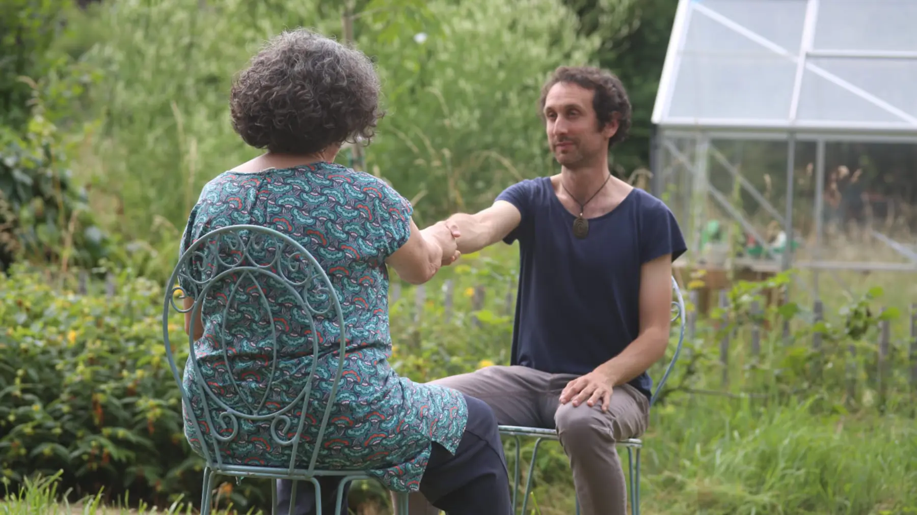 Un échange assis dans un jardin, près de la serre